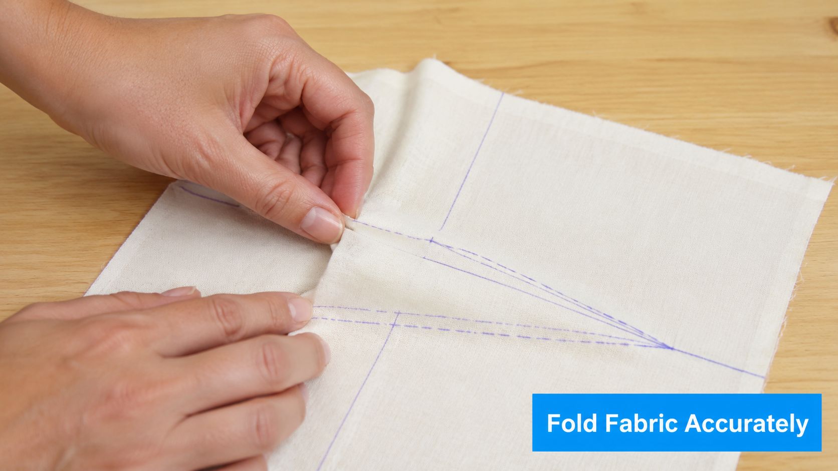 A pair of hands carefully folding fabric to align markings for sewing a dart into a garment.