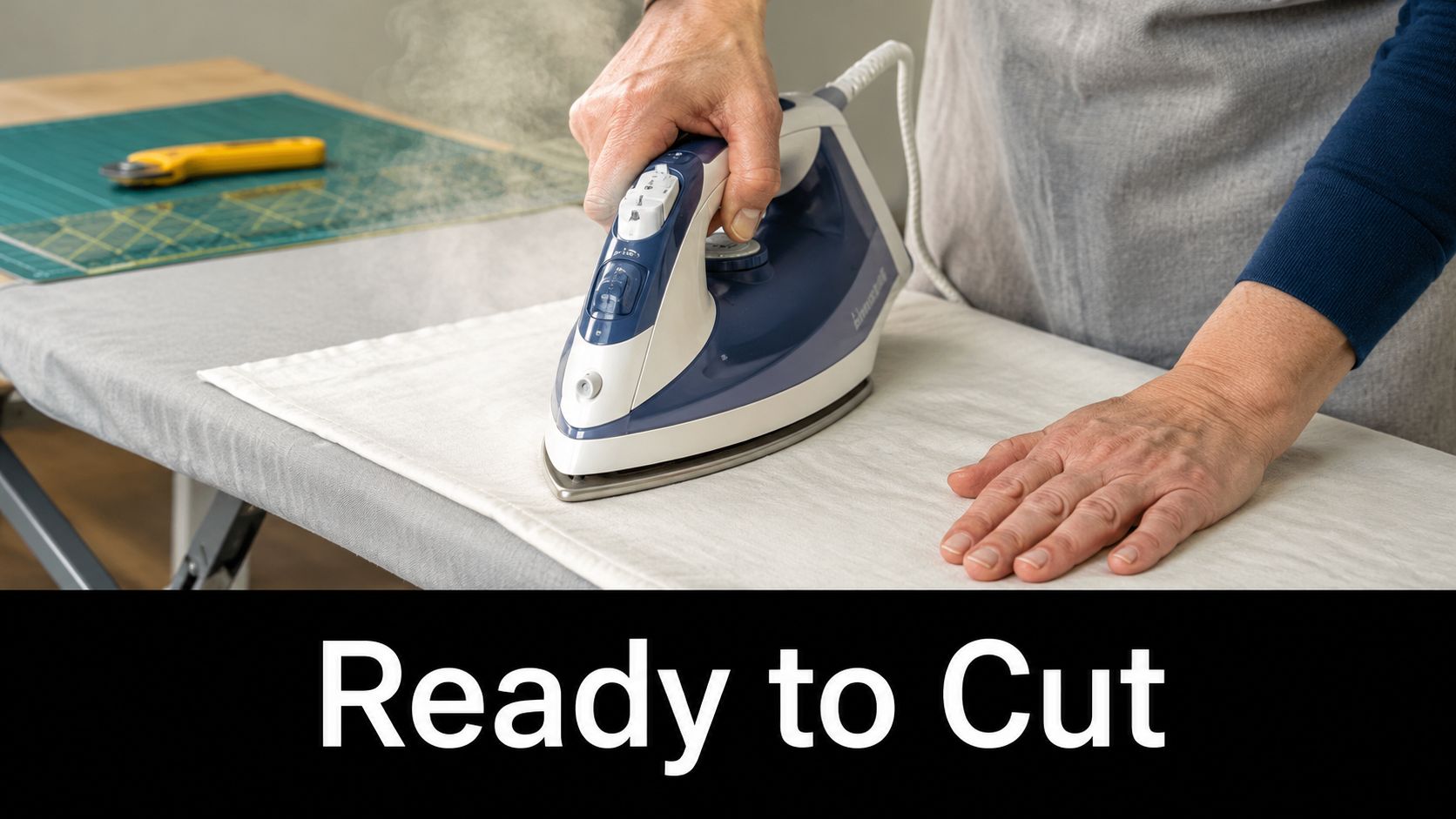 A person ironing fabric on an ironing board in preparation for a sewing and cutting project.