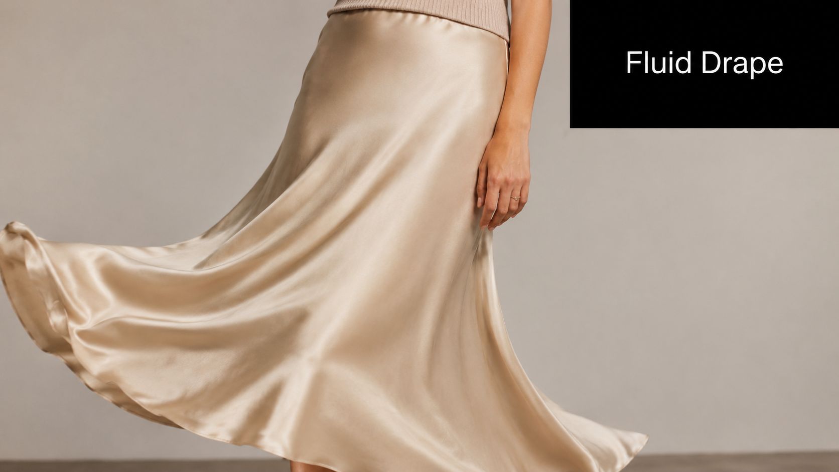 A model wearing a champagne-colored silk satin bias-cut midi skirt that flows gracefully while in motion.